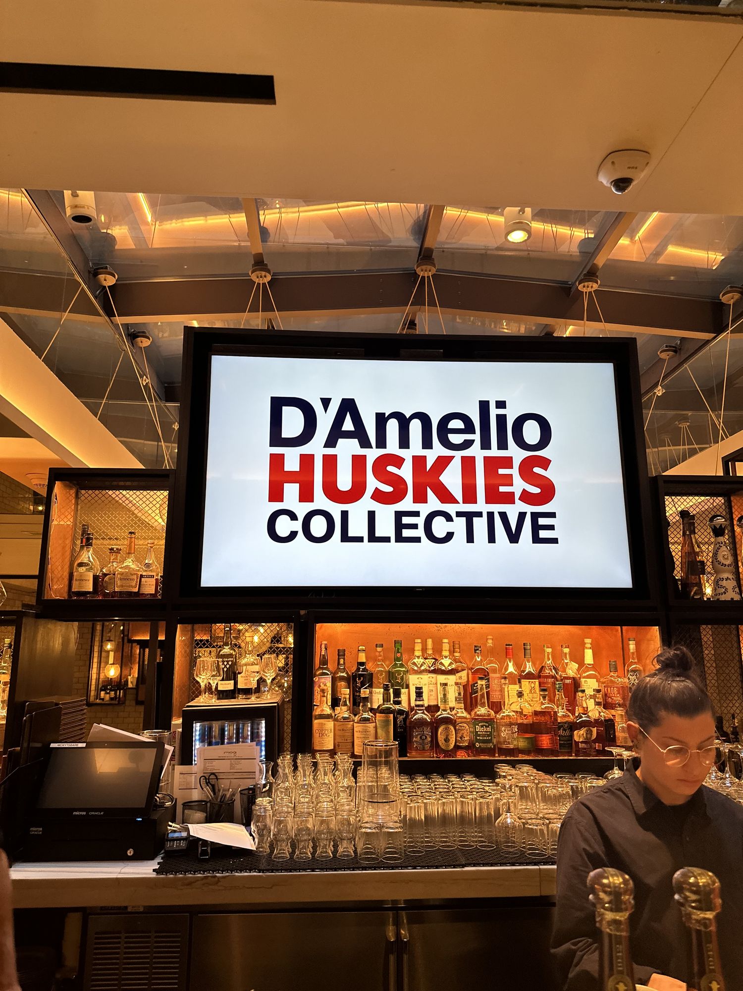 D'Amelio Huskies Collective branding on screen at a private dinner in New York City